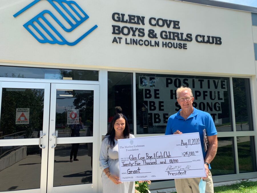 Two people outside a building with a sign saying Glen Cover Boys & Girls Club at Lincoln House