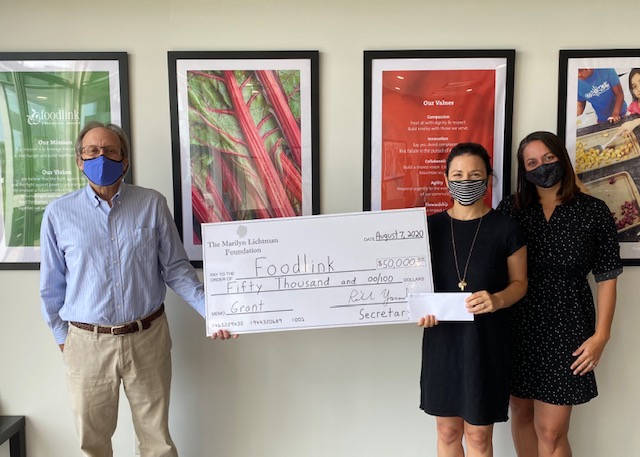 Three people holding an oversized check