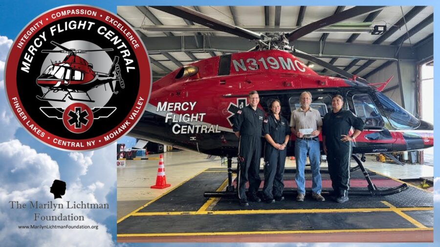 Image of four people standing in front of a helicopter. Image and text Mercy Flight Central Integrity, Compassion, Excellence Finger Lakes, Central NY, Mohawk Valley The Marilyn Lichtman Foundation www.MarilynLichtmanFoundation.org