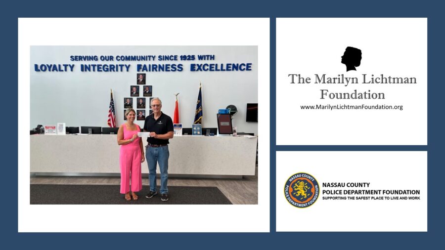Image of 2 people in front of a desk with sign Serving our community since 1925 with Loyalty Integrity Fairness Excellence. Logo and text 'The Marilyn Lichtman Foundation www.MarilynLichtmanFoundation.org ; Nassau County Police Department Foundation Supporting the safest place to live and work.