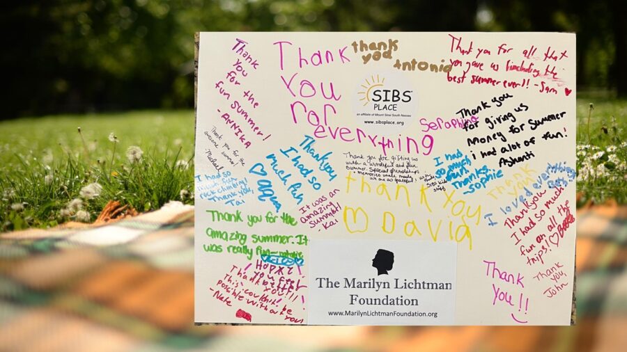 Background of a lawn and blanket, photo of text with thank you notes and logos of SIBS place and The Marilyn Lichtman Foundation