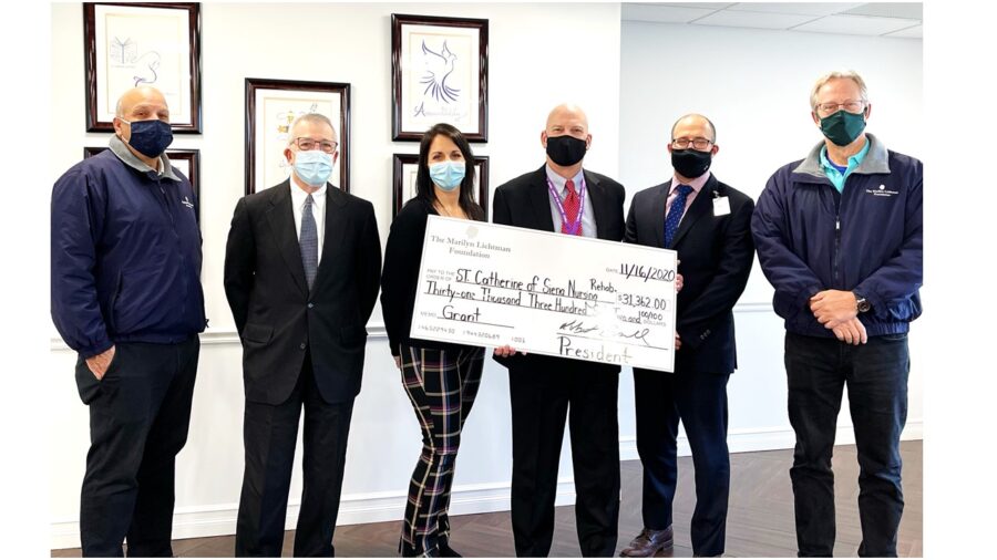 Photo of six people and an oversized check