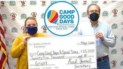 image of two people holding oversized check and Camp Good Days logo
